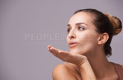 Buy stock photo Skincare, kiss and young woman in a studio with health, wellness and dermatology routine. Cosmetic, confident and female person with natural facial treatment and flirt gesture by gray background.