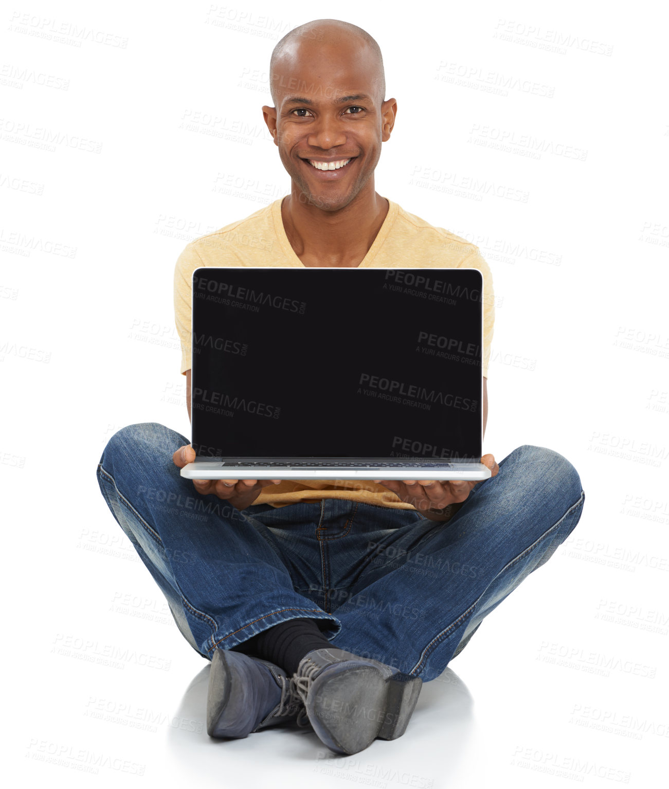Buy stock photo Studio shot of a smiling African-American man sitting and holding a laptop out in front of him