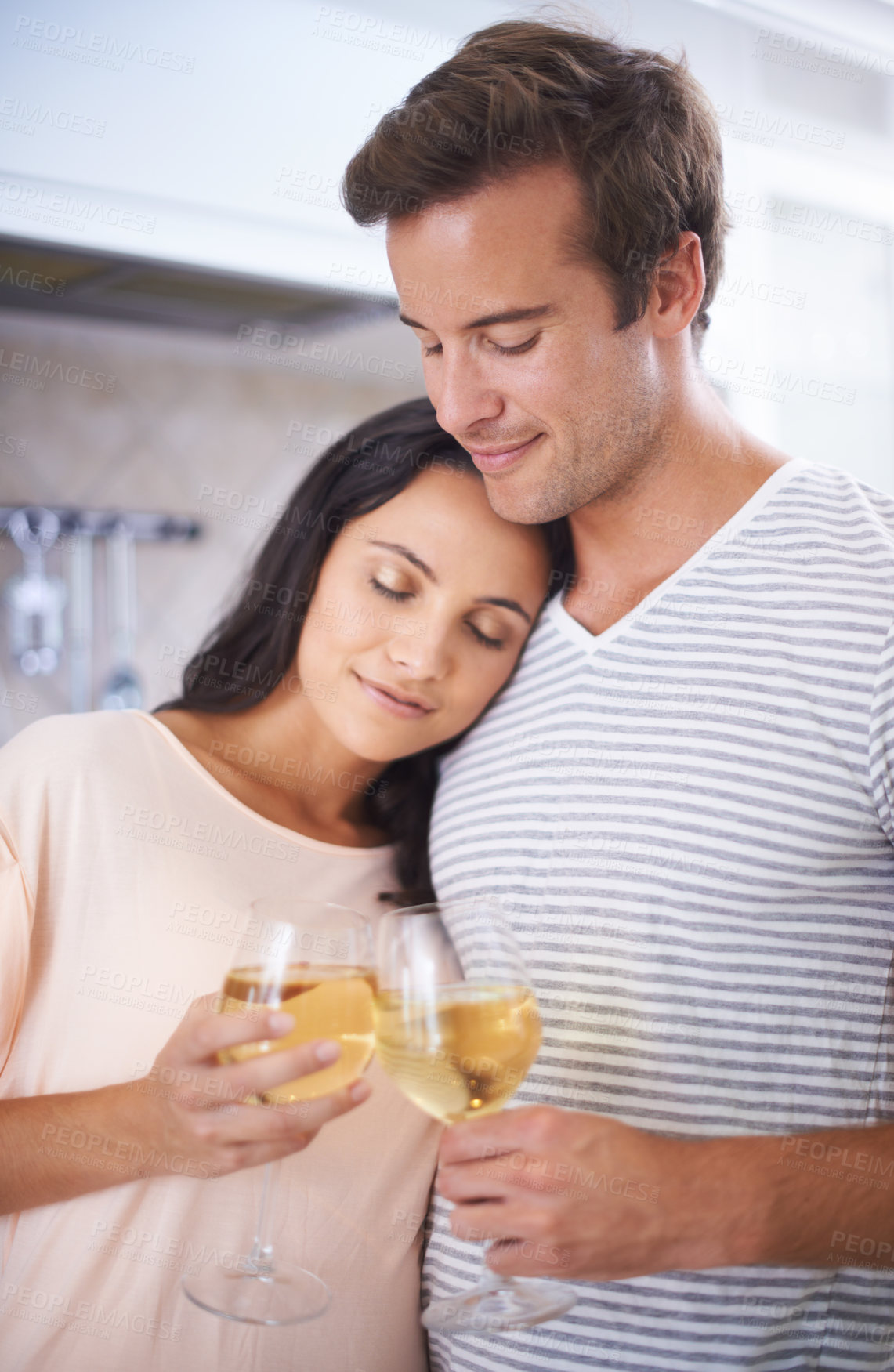 Buy stock photo Couple, embrace and wine glasses in kitchen, anniversary celebration and commitment to relationship. Happy people, home and bonding together in marriage, alcohol and toasting for support and romance