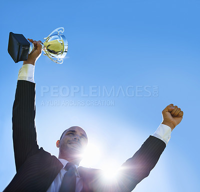 Buy stock photo Winning, businessman and outdoor celebration with trophy, happiness and achievement of success. Career, goals and man with victory of award or prize on blue sky with pride and inspiration in business