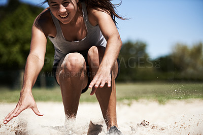 Buy stock photo Woman, sand and long jump athlete outdoor training for endurance competition, skill or performance. Female person, face and fitness goal for cardio achievement practice or leap run, wellness or sport