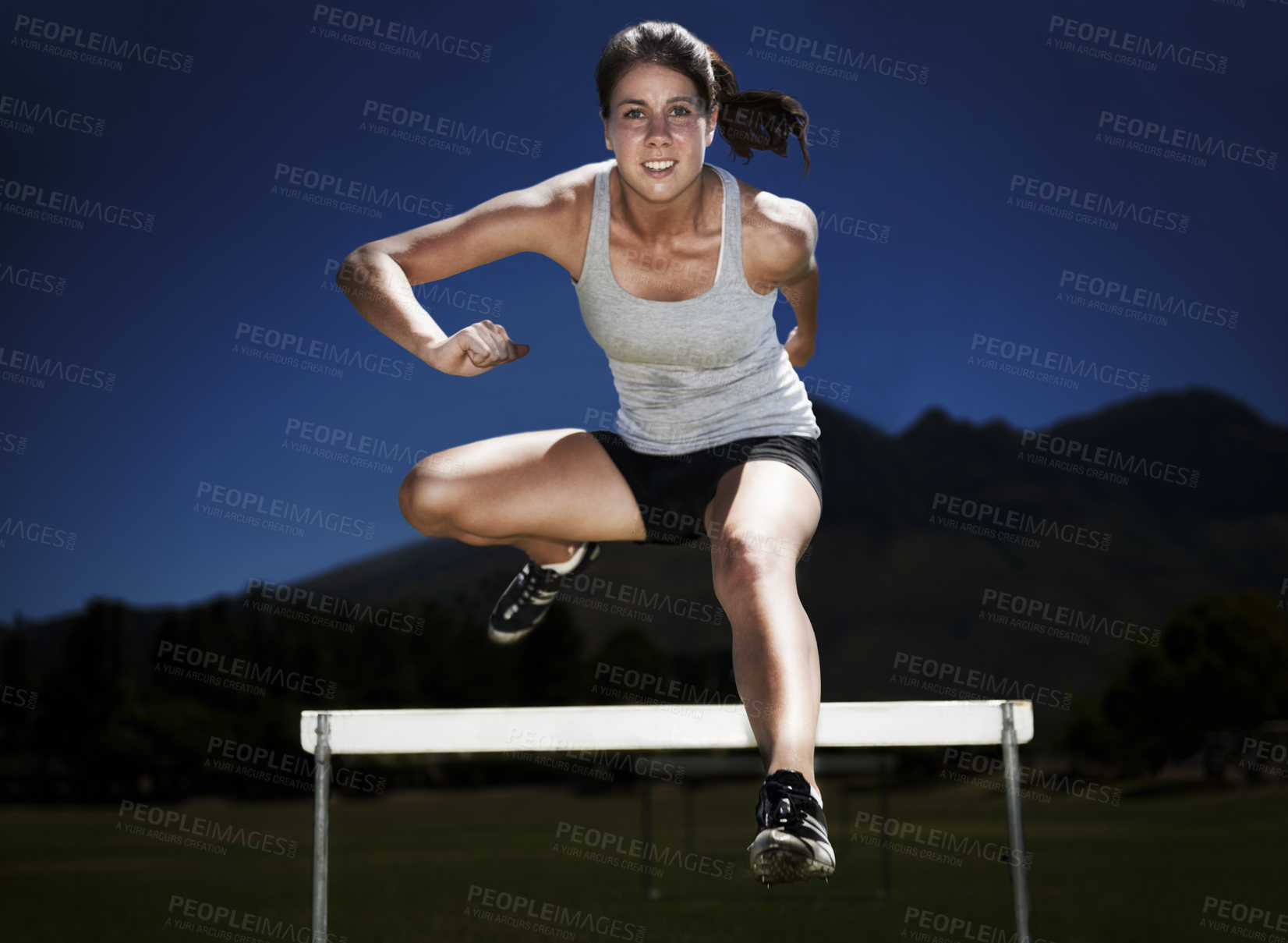 Buy stock photo Woman, portrait and hurdle jumping training for fitness sport practice, endurance or performance. Female person, face and leap outdoor at dark night for athletics health or exercise, race or workout