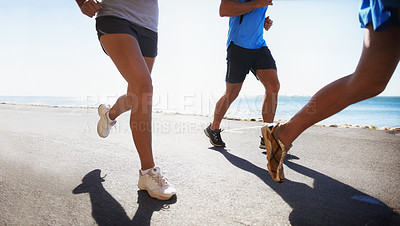 Buy stock photo People, fitness and legs running at beach for exercise or outdoor workout together on asphalt or road. Closeup of athletic group or runners in sports, teamwork or cardio training by the ocean coast