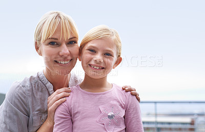Buy stock photo A happy mother and daughter standing outside smiling at the camera