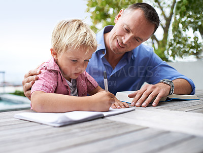 Buy stock photo Shot of a father helping his son with his coloring book