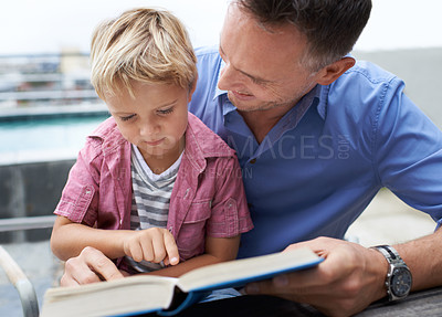 Buy stock photo Book, learning and dad with son reading at table on patio for child development, knowledge and studying. Education, books and help, happy father and kid student with story, home school and support.