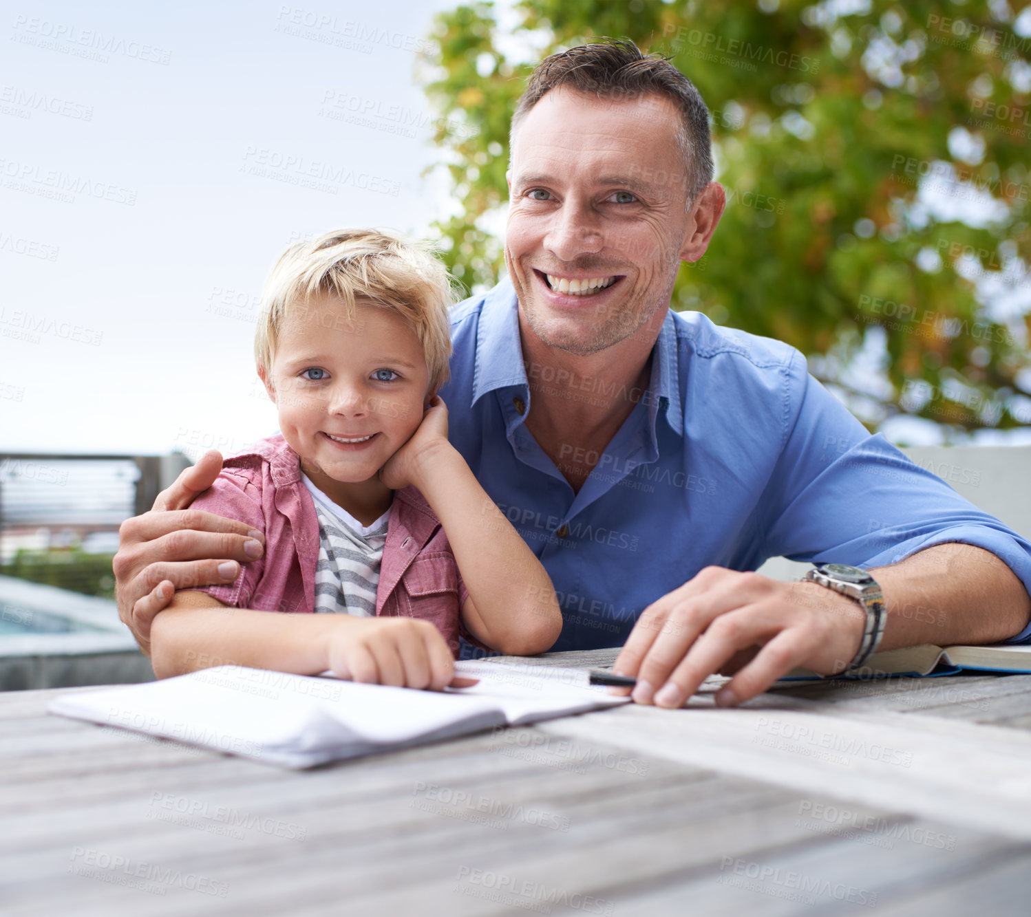 Buy stock photo Portrait, homework and dad with son at table in backyard for child development, knowledge and studying. Education, books and help, happy man and kid on patio with notebook, fun learning and drawing.