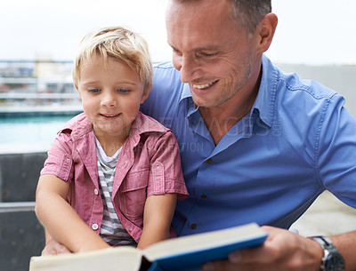 Buy stock photo Shot of a father reading to his little boy