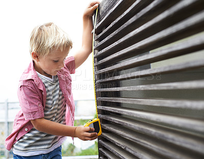 Buy stock photo Cute, measuring tape and boy kid doing maintenance on wood gate for fun or learning. Focus, equipment and young child working on repairs with tool for home improvement outdoor at modern house.