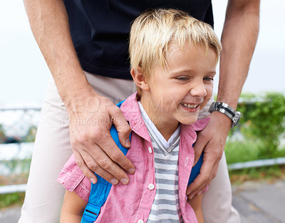 Buy stock photo A little boy smiling outside with his dad standing behind him