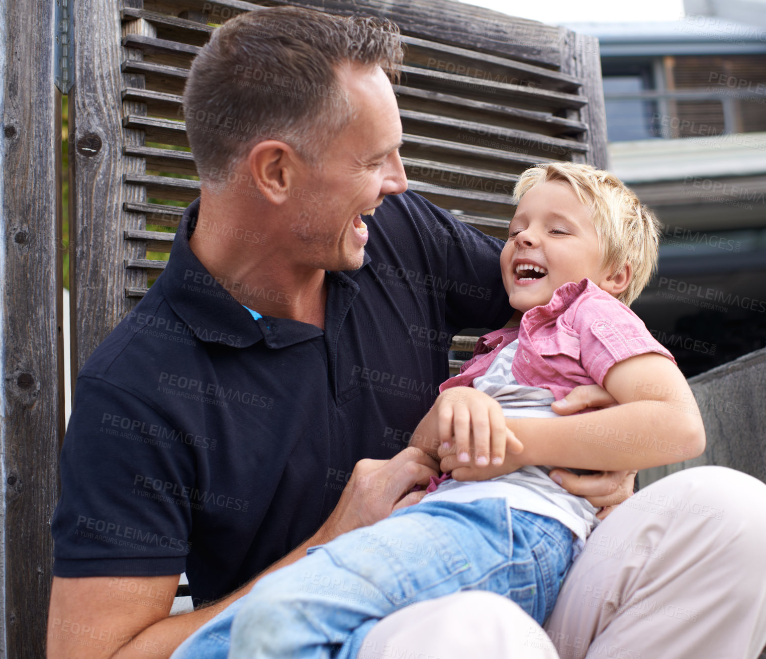 Buy stock photo Laughing, happy and father tickling child for bonding together in backyard at family home. Smile, funny and dad playing and having fun with boy kid by wood gate for quality time outdoor a house.