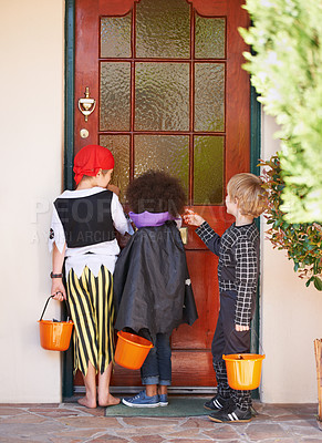 Buy stock photo Rearview shot of some children knocking on a door during halloween