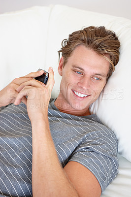 Buy stock photo Phone, thinking and happy man relax on a sofa with social media, chat or texting while streaming in his home. Smartphone, daydreaming or male person search for online dating, meme or web subscription
