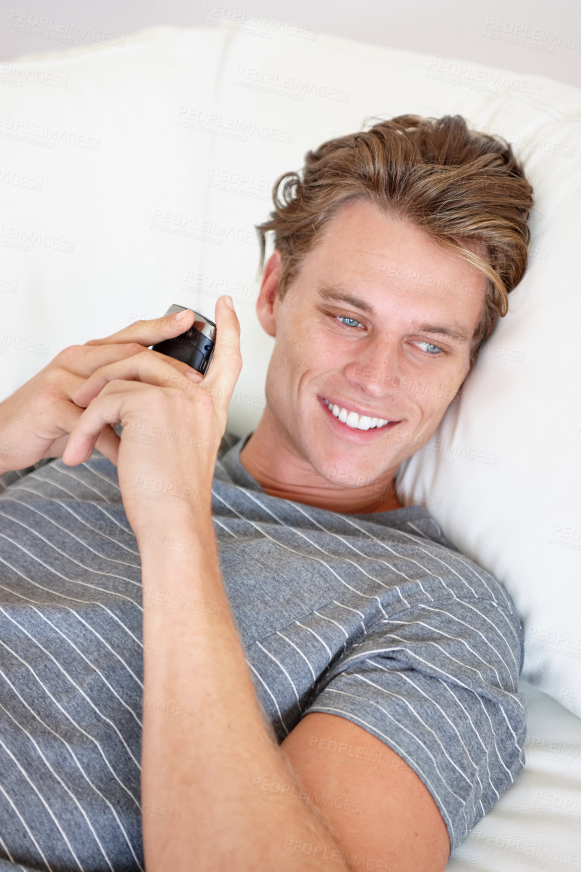 Buy stock photo Phone, thinking and happy man relax on a sofa with social media, chat or texting while streaming in his home. Smartphone, daydreaming or male person search for online dating, meme or web subscription