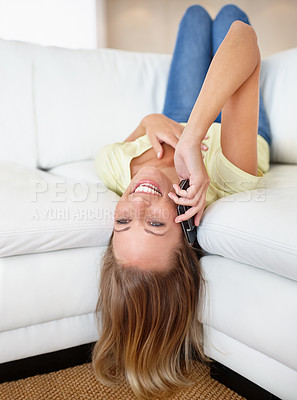 Buy stock photo Happy, phone call and woman upside down on a sofa with gossip, speaking or communication in her home. Smartphone, contact and female person lying in a living room with conversation or discussion