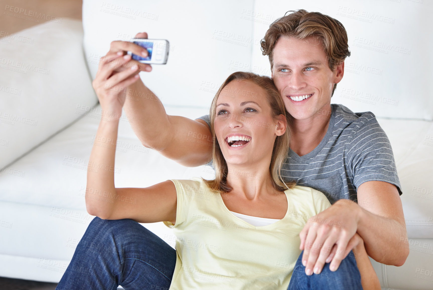 Buy stock photo Love, selfie and couple hug in a living room for bonding, photography or memory in their home. Happy, photo or people embrace in a house with phone for social media, blog or profile picture update