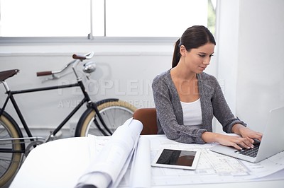 Buy stock photo Woman, computer and blueprint for architecture, construction and design planning in a startup office.Young engineering worker or designer typing on laptop with floor plan development for project