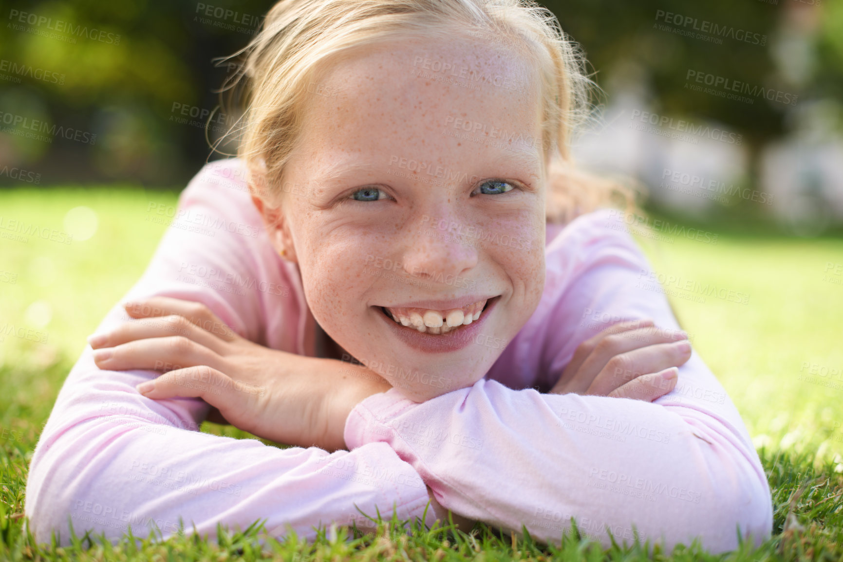 Buy stock photo Happy, portrait and girl child lying in grass for fun, play and adventure in nature. Face, smile and kid in garden with positive attitude, mindset and excited for exploring, learning or weekend break