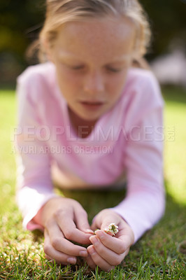 Buy stock photo Girl, kid and relax on grass with flower, spring or summer with nature and chill in park. Environment, plant and young child lying in field, backyard or garden with hands, outdoor and playing