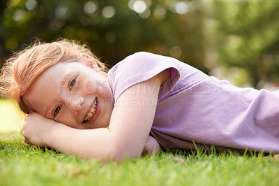 Buy stock photo Happy, portrait and young girl on grass, relax outdoor for fun and rest in garden or backyard. Youth, free time and playing in park, field or environment with smile on face for summer vacation