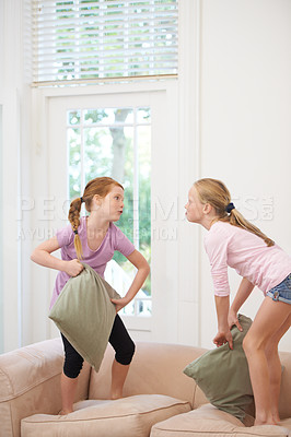 Buy stock photo Happy siblings, pillow fight and girls playing on sofa in living room together for fun bonding at home. Couch, children or kids enjoying playful game, entertainment or weekend with pillows in lounge