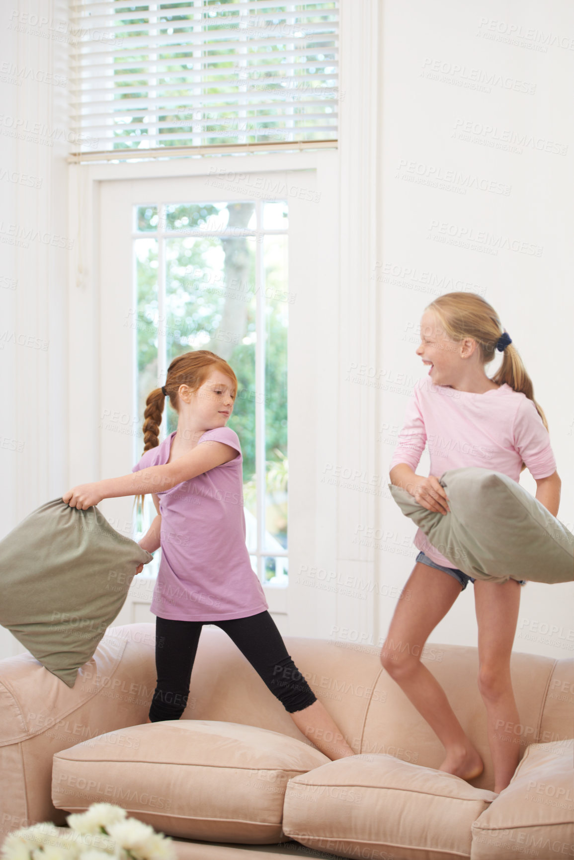 Buy stock photo Happy kids, pillow fight and girls playing on sofa in living room together for fun bonding at home. Couch, siblings or children enjoying playful game, entertainment or weekend with cushions in lounge