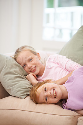 Buy stock photo Family, portrait and girl siblings on a sofa with love, comfort and care, resting and bonding in their home together. Happy, relax and face of sisters lying in a living room with trust and affection
