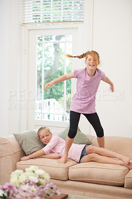 Buy stock photo Two sisters playing on the couch