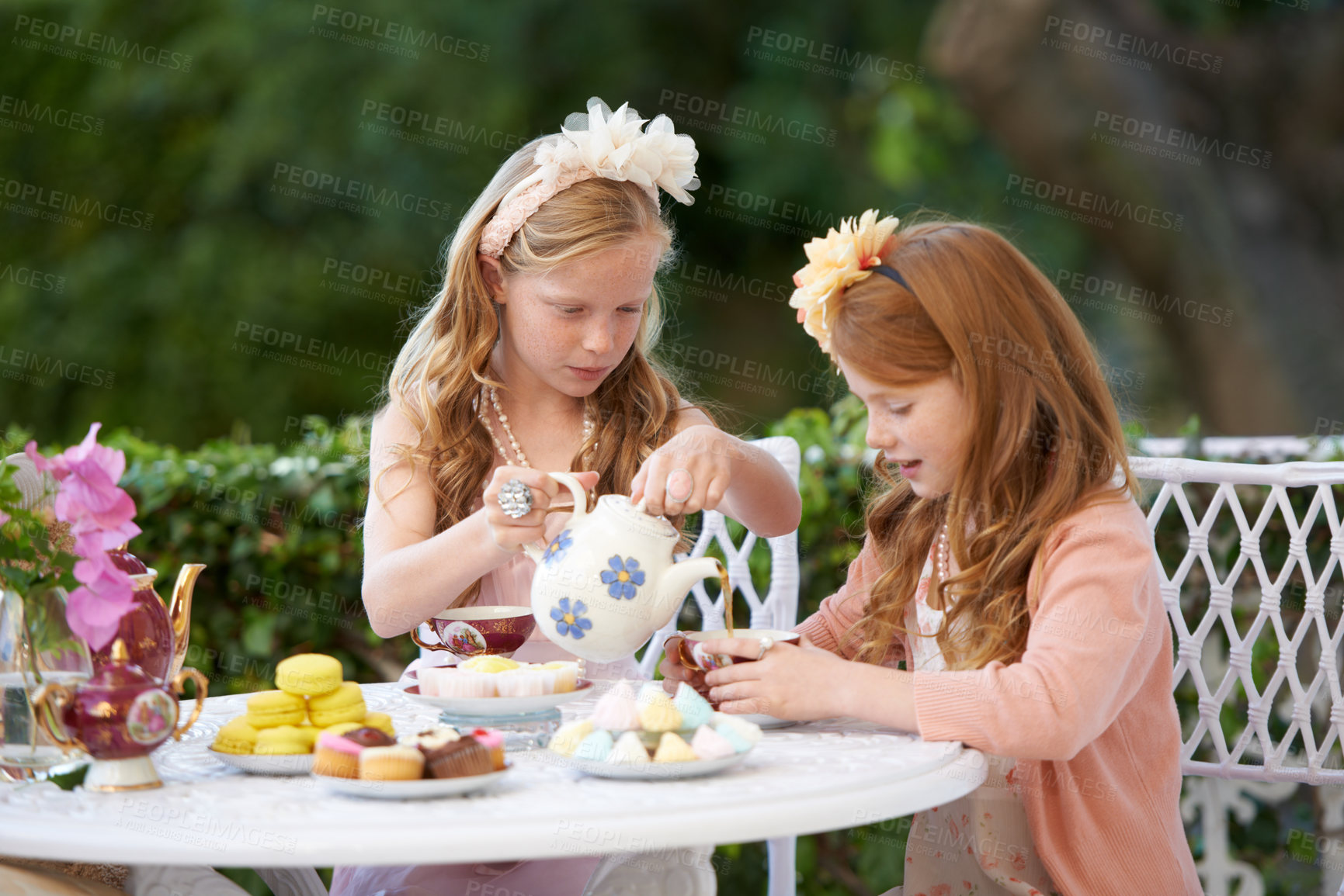 Buy stock photo Girl, friends and tea party in backyard or cupcakes for dessert or dress up game, fantasy or playing. Female people, siblings and pot for hot drink in garden for summer event fun, lunch or birthday