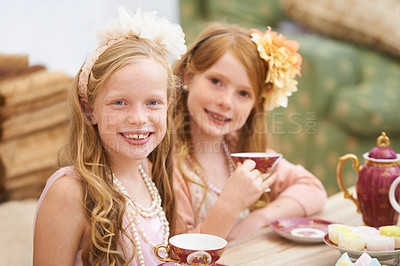 Buy stock photo Two friends dressing up and having a tea party outside in the garden