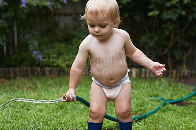 Buy stock photo Baby, playing with hose and garden, water and  development with growth, curiosity and backyard. Toddler, child and infant in gardening, alone and childhood for skills, milestone and coordination
