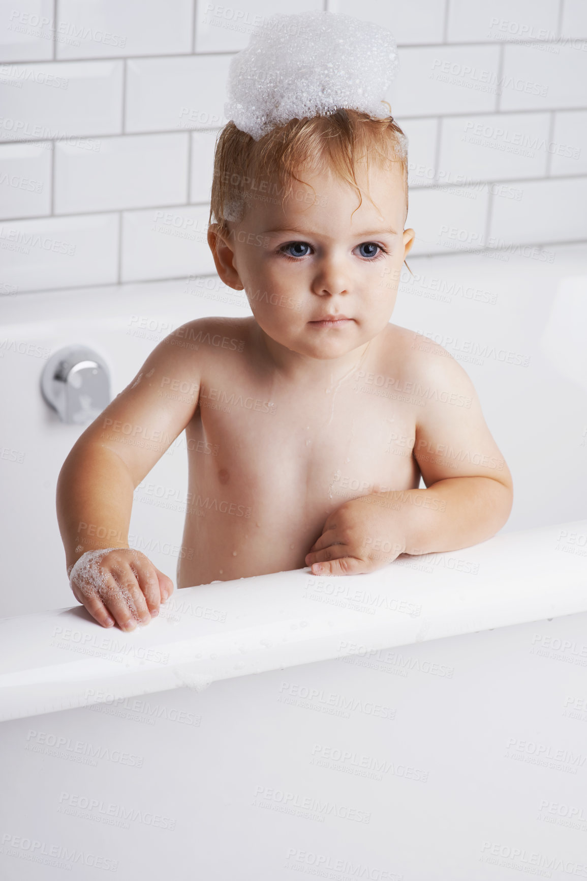 Buy stock photo An adorable baby boy standing in the bathtub