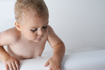 Buy stock photo Kid, baby and boy in bathtub of water for morning routine, skincare and wellness at home in bathroom. Toddler, wet child and washing with soap, foam and bubbles for cleaning, hygiene or mockup space