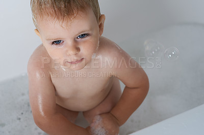 Buy stock photo Baby, child and bubbles in bath of water for morning routine, skincare and cleaning at home from above. Boy, wet kid and toddler thinking in bathtub of soap, foam and washing for hygiene in bathroom