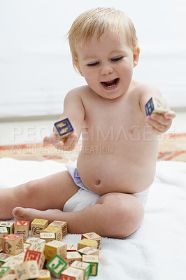 Buy stock photo Playing, kid and baby with his learning cubes, happiness and smile with joy, fun and education. Growth, cheerful and child development with toys, active and excited with games, wooden blocks or peace