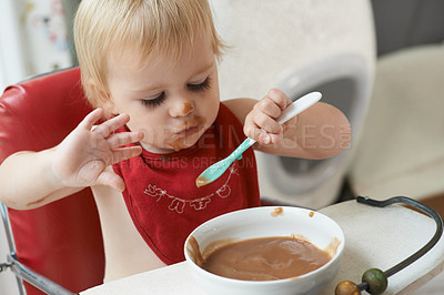 Buy stock photo High chair, eating and baby with spoon in a house for nutrition, diet and fun while playing. Food, messy eater and boy kid at home with meal for child development, fiber or vitamins while learning