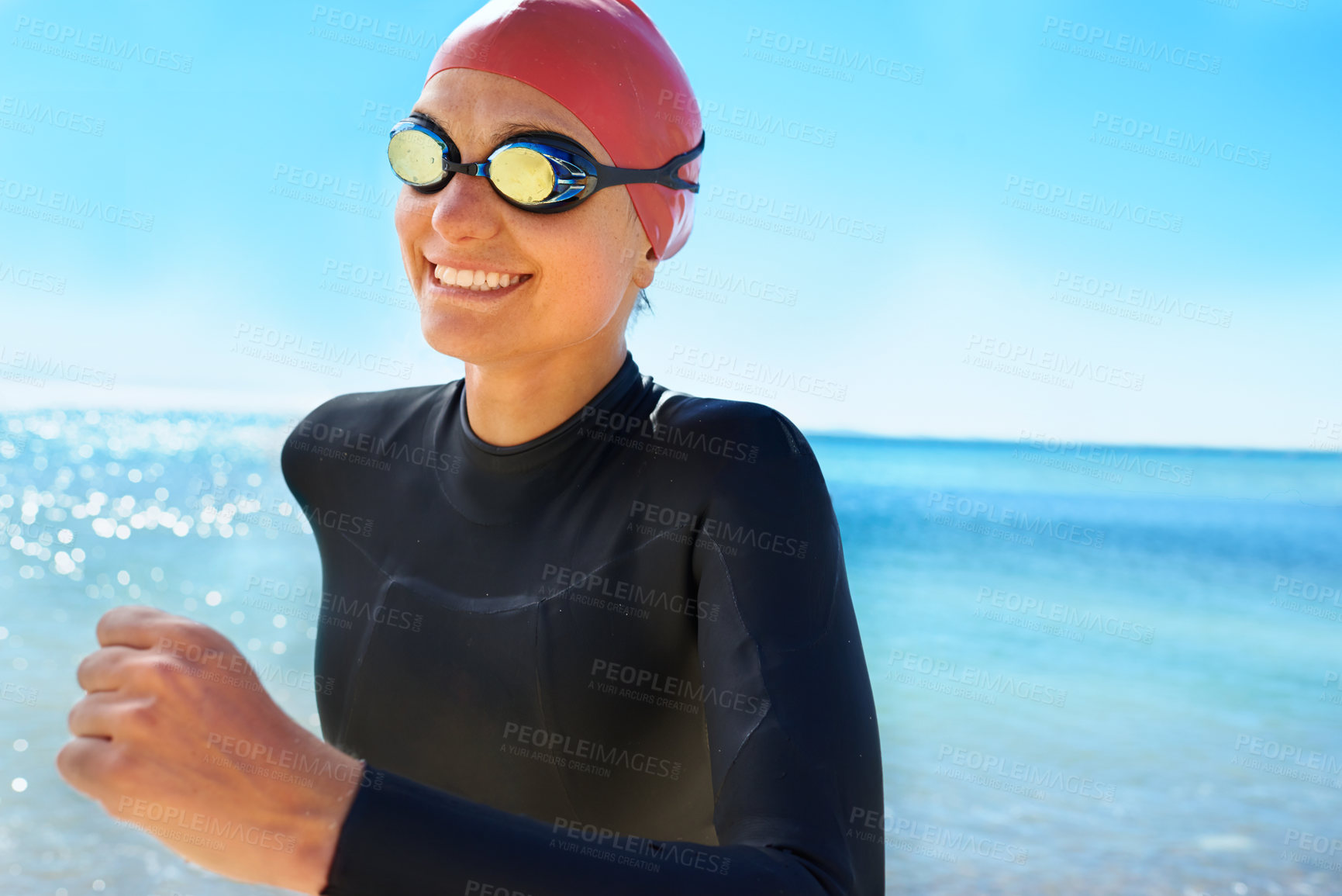 Buy stock photo A young woman training in a full piece wetsuit and swimming gear on the beach in the winter