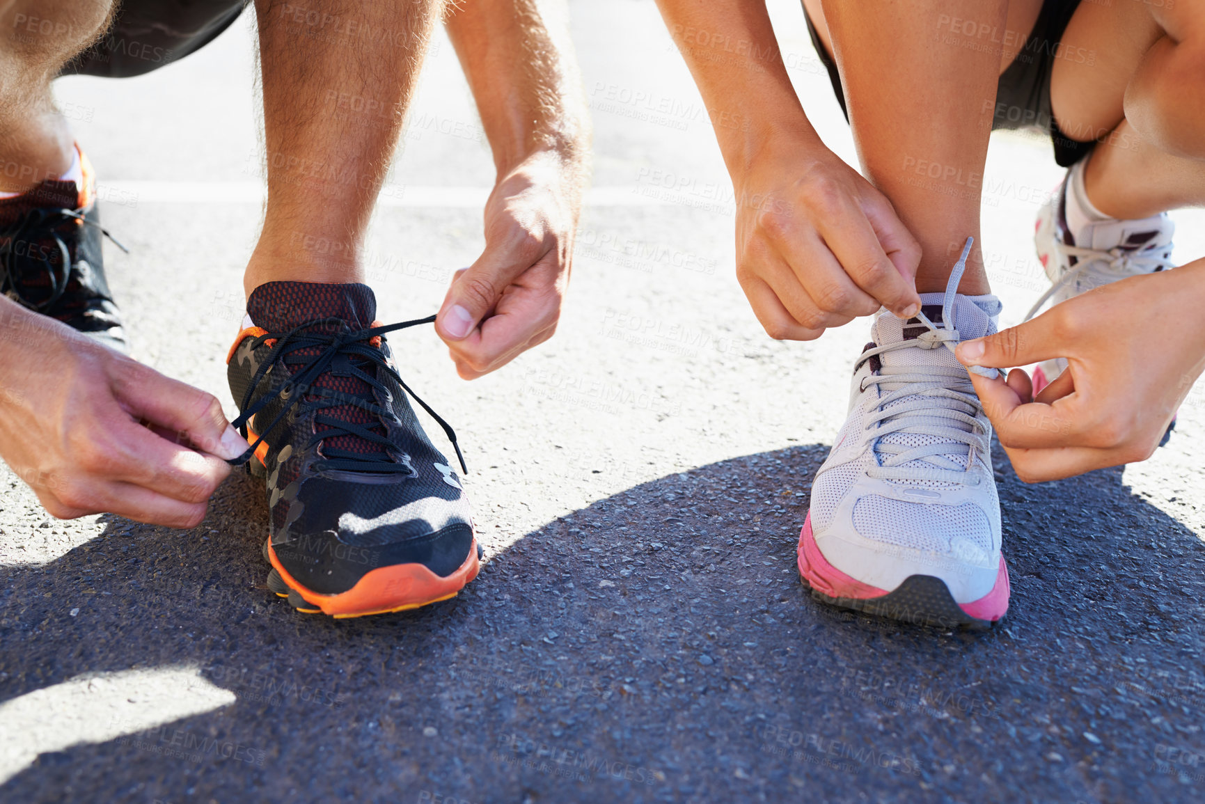Buy stock photo Cropped shot of two athletes tying their shoelaces