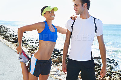 Buy stock photo An attractive young woman leaning on her boyfriend while stretching her quads
