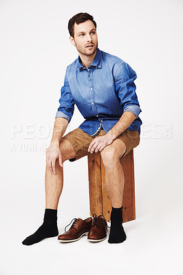 Buy stock photo A handsome young man putting on his shoes