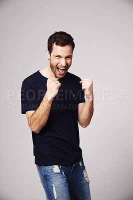 Buy stock photo A handsome young man celebrating in studio
