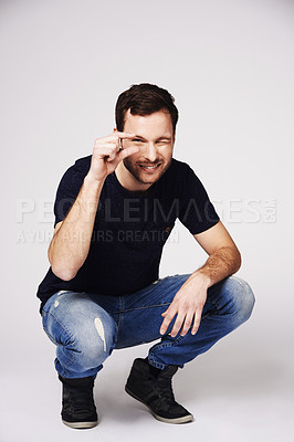 Buy stock photo Size, small and hand gesture with portrait of man in studio for sign, opinion and measurement. Happy, smile and idea with male person isolated on white background for scale, review and happiness
