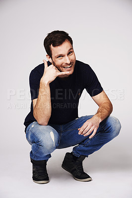 Buy stock photo Man, portrait and call me hand sign of a person with flirty and emoji gesture in studio. Isolated, grey background and male model with a smile and happiness from flirt and casual fashion alone