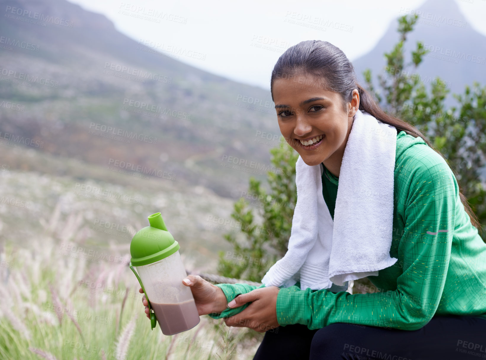 Buy stock photo Portrait of an attractive young woman holding a sports drink outdoors