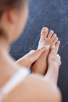 Buy stock photo Cropped over the shoulder shot of a ballerina massaging her foot