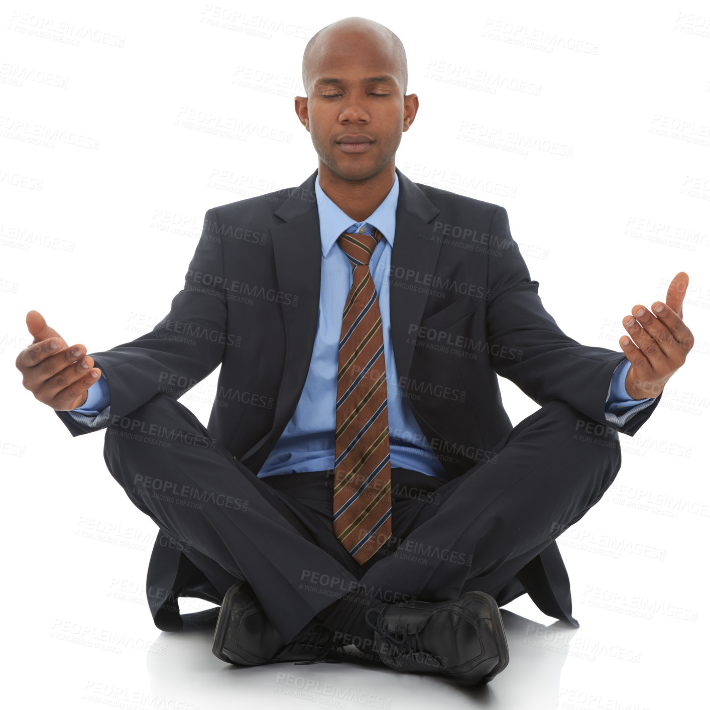 Buy stock photo An African-American businessman sitting meditating against a white background