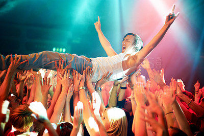 Buy stock photo A young man cheering as he crowd surfs at a concert. This concert was created for the sole purpose of this photo shoot, featuring 300 models and 3 live bands. All people in this shoot are model released.