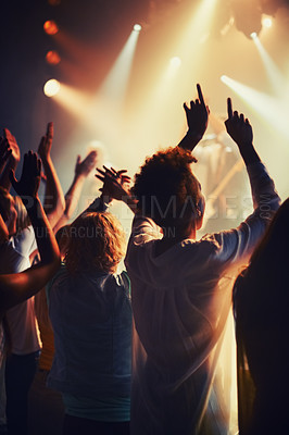 Buy stock photo Concert, fans and people dance to music, event and lights on stage for performance at festival. Nightclub, party and back of audience or excited crowd listening to musician and sound with freedom