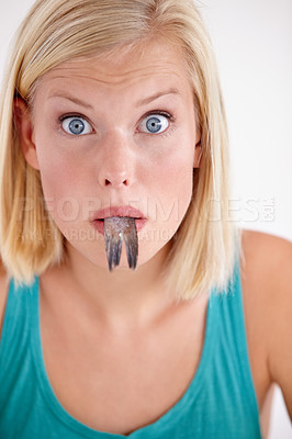Buy stock photo Surprise, woman and portrait eating fish with shock on white background of studio. Wow, crazy and person on diet with fear of weird seafood, cuisine and disgust in mouth for gross, tail and food