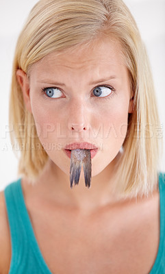 Buy stock photo Face, woman and confused with eating fish, tail and surprise on white background of studio. Crazy, diet and person with doubt in weird seafood, cuisine and taste gross or strange food in mouth